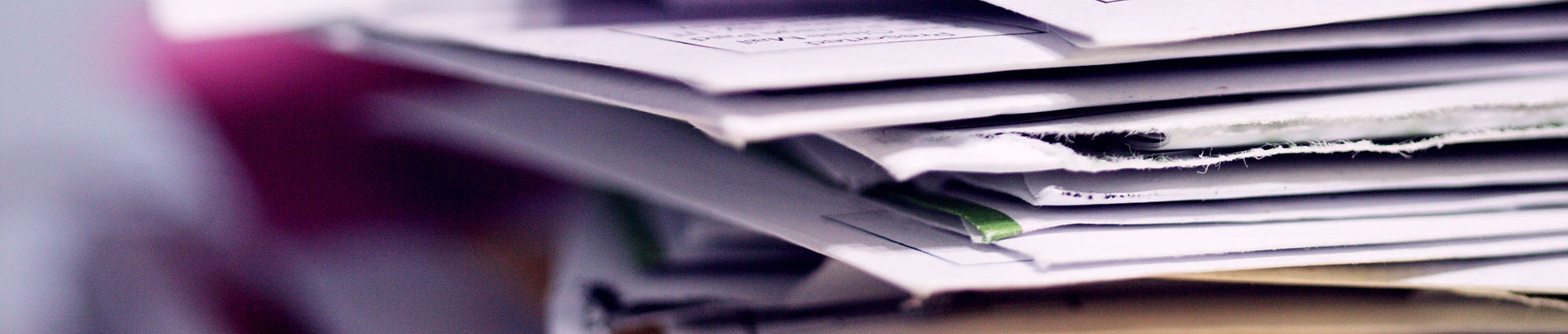 A stack of documents and opened envelopes.