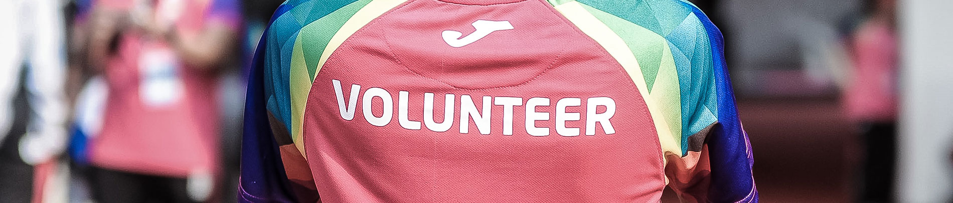 A person wearing a colourful t-shirt that says volunteer across the back.